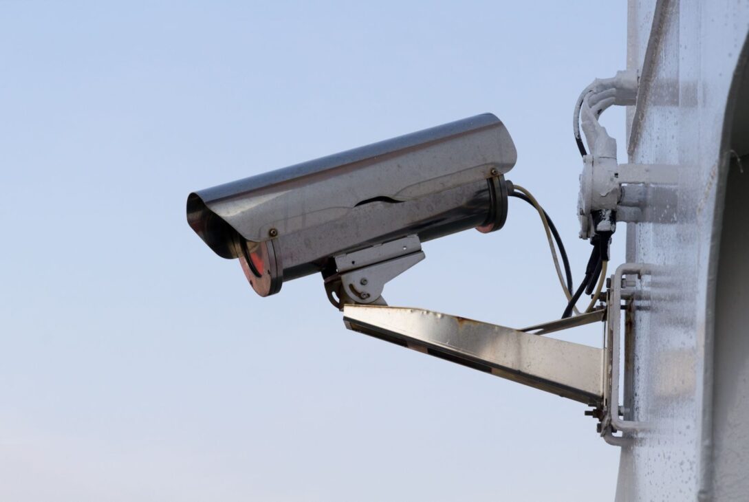 Close-up of an outdoor CCTV camera installed on a wall for security purposes.